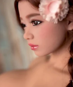 Alice Sex Doll 161cm Bonnet E, gros plan profil, fleur rose dans les cheveux, regard intense.