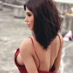 Ambre Sex Doll 165cm Bonnet F en robe rouge, vue de dos montrant cheveux bruns et épaules nues.