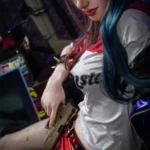 Amara Sex Doll 166 cm IronTech, pose assise, tenue cosplay, cheveux bicolores, pistolet en main.