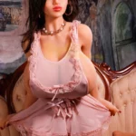 Amara Sex Doll 140 cm IronTech Doll TPE en lingerie rose assise sur un canapé vintage.