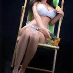 Amorie Sex Doll 165 cm IronTech en maillot blanc, assise sur un transat, tenant une fleur.