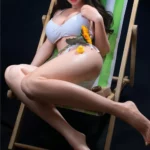 Amorie Sex Doll 165 cm IronTech en bikini blanc, posée sur une chaise longue avec accessoires.