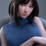 Anabelle Sex Doll 166 cm IronTech en pull bleu, pose assise, cheveux bruns avec barrette.