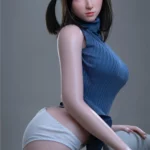 Anabelle Sex Doll 166 cm en pose assise, portant un haut bleu et une culotte blanche.