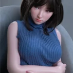 Anabelle Sex Doll 166 cm IronTech, assise, cheveux bruns, robe bleue côtelée.