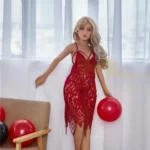 Aurélie Sex Doll 150 cm en robe rouge dentelle, pose debout près d'une fenêtre avec ballon rouge.