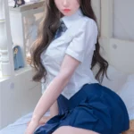 Bellora Sex Doll 168 cm IronTech en uniforme scolaire, assise sur un lit, cheveux longs.