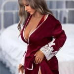 Dollya Sex Doll 165 cm IronTech en robe rouge, pose assise élégante, cheveux blonds ondulés.