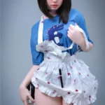 Elyzabelle Sex Doll 164 cm en tablier blanc, pose debout, cheveux bruns, t-shirt bleu.