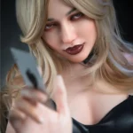 Emiluna Sex Doll 168 cm IronTech, cheveux blonds, robe noire, pose séduisante de face.