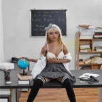 Emmarose Sex Doll 150 cm IronTech Doll TPE assise sur un bureau, tenue écolière, globe terrestre.