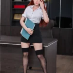 Emmilia Sex Doll 166 cm IronTech en tenue de bureau, debout près d'un bureau, tenant un classeur.
