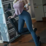 Evelynia Sex Doll 165 cm IronTech en tenue de sport, tenant un haltère dans une salle de gym.