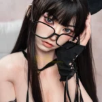 Isadora Sex Doll 165 cm IronTech en tenue de chat, lunettes et gants noirs, pose assise.