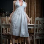 Lelia Sex Doll 164 cm en robe blanche, posant debout dans une salle à manger élégante.