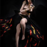 Lilika Sex Doll 166 cm IronTech en robe noire, pose assise élégante, cheveux longs noirs.