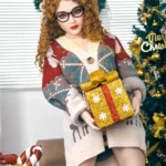 Lilika Sex Doll 150 cm IronTech en pull de Noël tenant un cadeau devant un sapin décoré.