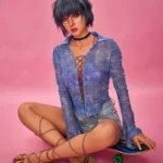 Lilun Sex Doll 168 cm IronTech, assise sur un skateboard, chemise bleue transparente, fond rose.
