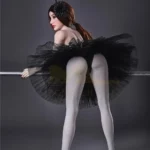 Lisette Sex Doll 150 cm IronTech en tutu noir, pose de dos, appuyée sur une barre.