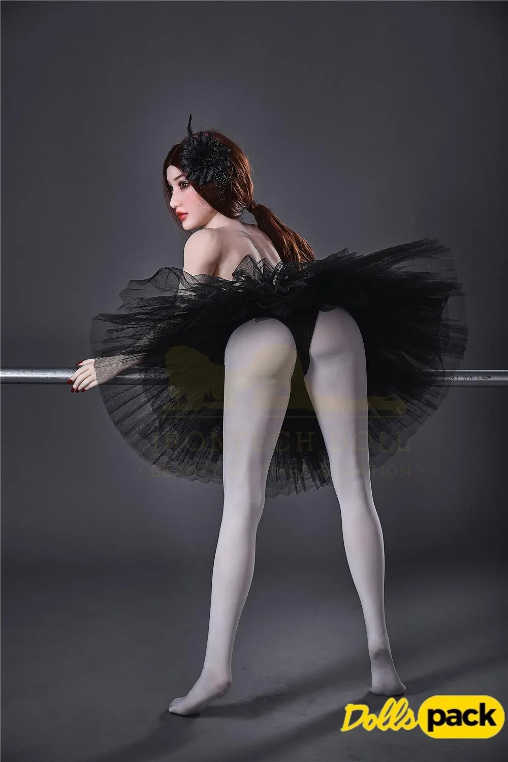 Lisette Sex Doll 150 cm IronTech en tutu noir, pose de dos, appuyée sur une barre.