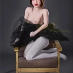 Lisette Sex Doll 150 cm IronTech Doll TPE en pose assise sur fauteuil, jupe noire volumineuse.