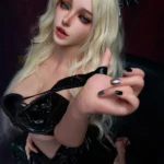 Lolita Sex Doll 164 cm IronTech en tenue noire brillante, cheveux blonds, pose assise séduisante.