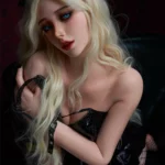 Lolita Sex Doll 164 cm IronTech Doll, pose assise, robe noire en cuir, cheveux blonds, fond sombre.