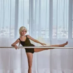 Lulaine Sex Doll 150 cm IronTech Doll TPE en pose de danse, jambe levée, devant fenêtre.