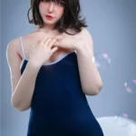 Luluza Sex Doll 168 cm en body bleu, pose debout, regard doux, cheveux bruns courts.