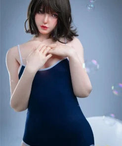 Luluza Sex Doll 168 cm en body bleu, pose debout, regard doux, cheveux bruns courts.