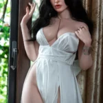 Lumibelle Sex Doll 166 cm IronTech Doll en robe blanche, pose près d'une fenêtre.