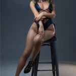 Poupée IronTech Lunora assise sur une chaise, habillée en lingerie séduisante