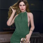 Luxina Sex Doll 166 cm IronTech en robe verte, main dans les cheveux, tenant une pochette dorée.