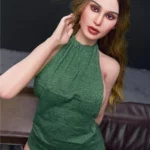 Luxina Sex Doll 166 cm IronTech en robe verte, posée sur un canapé, regard vers l'avant.