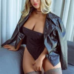 Luxine Sex Doll 164 cm IronTech Doll assise, veste en cuir, corset rayé, bas dentelle, ambiance élégante.