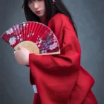 Lyria Sex Doll 164 cm IronTech en kimono rouge, éventail fleuri en main, pose élégante.