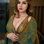 Mirabelle Sex Doll 166 cm IronTech Doll Silicone, vêtue d'une robe dorée et châle coloré, pose debout.