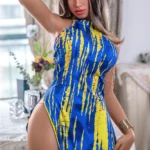 Valora Sex Doll 164 cm IronTech en robe bleue et jaune, pose élégante près d'une table.