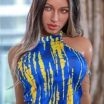 Valora Sex Doll 164 cm IronTech en robe bleue à motifs jaunes, posée devant une fenêtre.