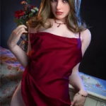 Valoria Sex Doll 168 cm en robe rouge, pose assise séduisante, fond floral.