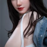 Vélyna Sex Doll 165 cm IronTech, pose assise, chemise en jean ouverte, regard direct.