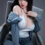 Vélyna Sex Doll 165 cm IronTech en jean, assise, pose séduisante, cheveux bruns.