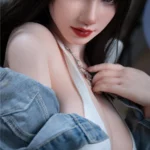 Vélyna Sex Doll 165 cm IronTech en jean, pose sensuelle, regard captivant.