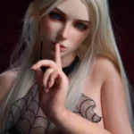 Ysella Sex Doll 164 cm IronTech, cheveux blonds, robe noire, pose doigt sur lèvres.