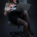 Zoella Sex Doll 168 cm IronTech en position assise, lunettes, tenue de bureau et ordinateur portable.