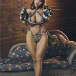 Aurélia Sex Doll 158 cm IronTech en tenue léopard, posant debout sur un canapé fleuri.