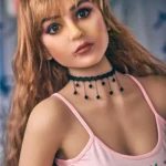 Auréline Sex Doll 163 cm IronTech avec cheveux longs ondulés et débardeur rose.