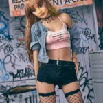 Auréline Sex Doll 163 cm IronTech en tenue décontractée, pose urbaine devant un mur graffité.