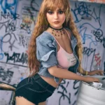 Auréline Sex Doll 163 cm IronTech en jean court, pose urbaine devant mur graffiti.