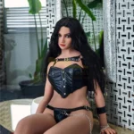 Avelina Sex Doll 168 cm en lingerie noire, assise, cheveux longs et noirs, ambiance moderne.
